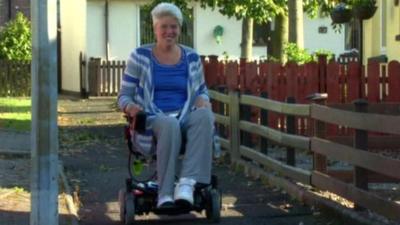 Andrea Brown tries out her donated electric wheelchair