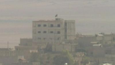 Building in Kobane with IS flag raised above it