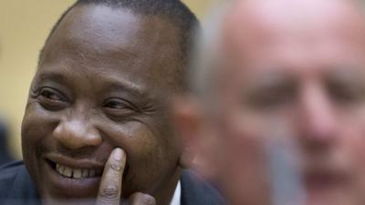 Kenya's President Uhuru Kenyatta (L) smiles as he appears before the International Criminal Court