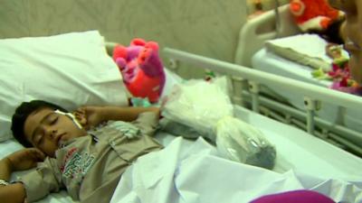 An injured Pakistani boy asleep in a hospital bed