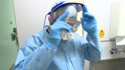 Nurse at North Manchester General Hospital putting on protective clothing in Ebola treatment rehearsal