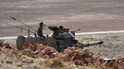 Turkish soldiers stationed on a hill facing the Syrian town of Kobane