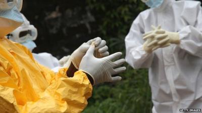 Health workers dress in protective clothing in Liberia, 13 October 2014