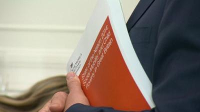 Close up shot of Alan Milburn holding copy of State of the Nation 2014 report