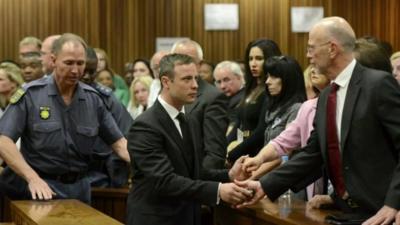 Oscar Pistorius shakes hands with his uncle Arnold as he is led away from court