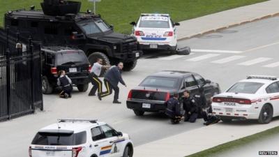 Police officers take cover near Parliament Hill