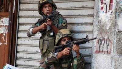 Lebanese army soldiers carry their weapons during clashes with Islamist militants in Tripoli October 25, 2014