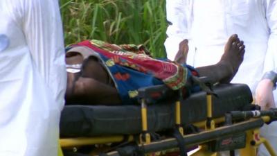 Annie, an Ebola patient, is carried on a stretcher to hospital in Liberia