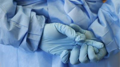 Gloved hands of army nurse seen during demonstration of an isolation chamber at Bundeswehr Clinc in Koblenz