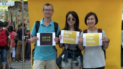 People pose for a photograph in Hong Kong