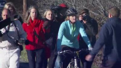 Kaci Hickox on bike ride surrounded by press