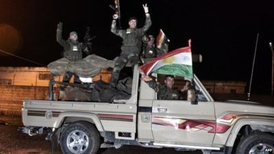 Kurdish Peshmerga fighters in truck flying Kurdish flag