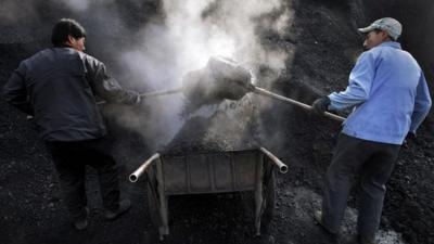 Chinese workers load coals to a cart in Miyun, north of Beijing, China