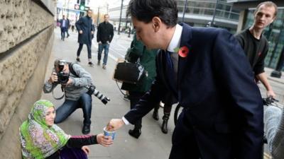 Ed Miliband gives money to a beggar in Manchester