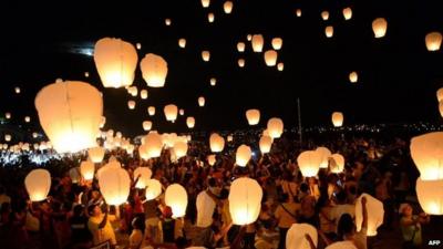 Crowds releasing paper lanterns