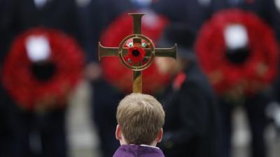 Boy holds cross at Cenotaph
