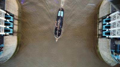 A tall ship passes under the newly installed glass floor 138 feet above the River Thames at Tower Bridge