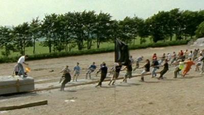 People dragging a concrete replica stone