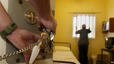 Guard locks prison cell door