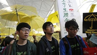 Alex Chow, centre, and Nathan Law, left, and Eason Chung, at Hong Kong International Airport - 15 November 2014