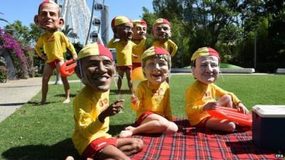 Protesters wearing paper mache heads of world leaders