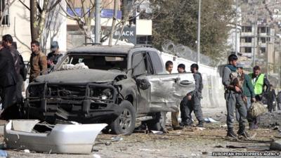 Security officials inspect the scene of a suicide car bomb attack which targeted Shukria Barakzai in Kabul, Afghanistan