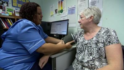 A doctor checks a patient's blood pressure