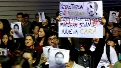 Protesters holding images of missing Mexico students