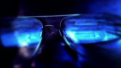 Computer screen reflected in a man's spectacles.