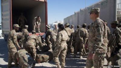 US Army guardsmen load a lorry with their luggage as they leave at the end of their tour at Kandahar airfield, 14 November 2014