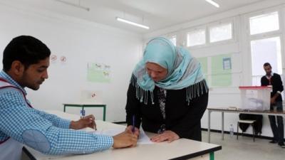 Tunisian woman collects ballot paper