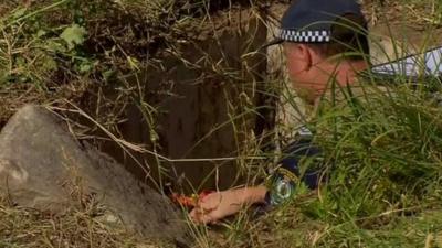 Policeman down a drain