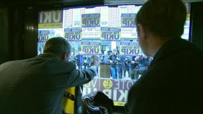 Nigel Farage waves from UKIP office