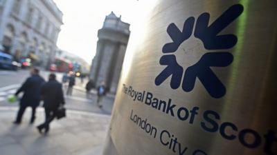 Pedestrians pass a Royal Bank of Scotland (RBS) bank branch