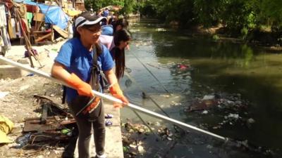 Workers in Manila cleaning up river