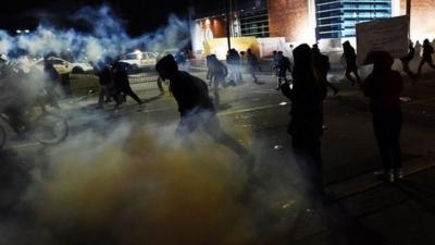 Demonstrators flee as police fire tear gas during clashes in Ferguson