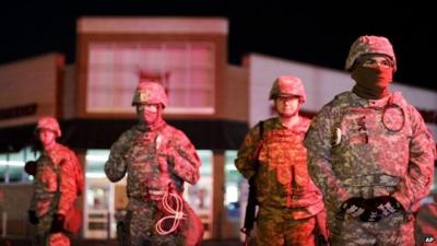 Missouri National Guard stand watch outside a store in Ferguson