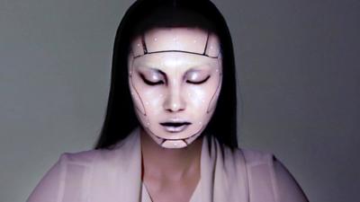 A model with a projection mapped onto her face