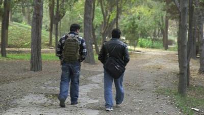 Two interpreters walking in park in Kabul