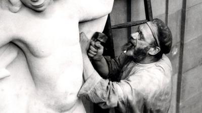 Eric Gill at work on the 'Prospero and Ariel' sculpture outside Broadcasting House