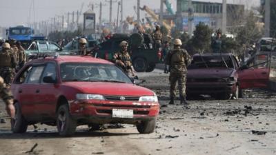 Afghan intelligence personnel inspect the site of a suicide attack on a British embassy vehicle along the Kabul-Jalalabad road in Kabul