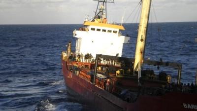 People are seen onboard a ship sailing a few miles southeast of the island of Crete