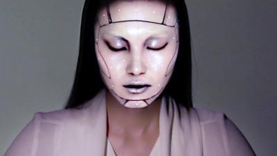 A model with a projection mapped onto her face