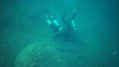 Divers examining what could be part of a medieval Chinese anchor