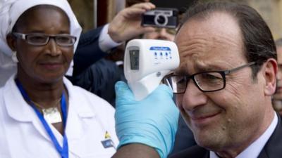 President Hollande has his temperature measured at a hospital in Conakry