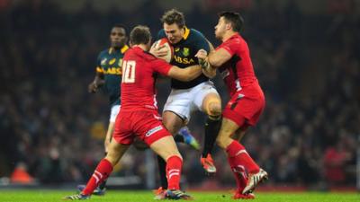 Wales players Dan Biggar and Rhys Webb tackle Jean de Villiers of South Africa during the Autumn international match between Wales and South Africa