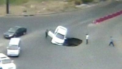 Car being swallowed by sinkhole