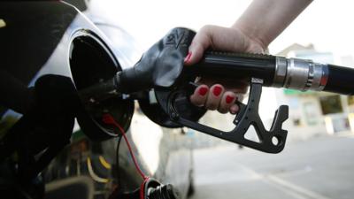 Hand on petrol pump filling up car