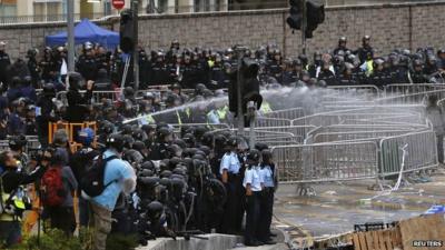 Riot police use a water cannon to disperse protesters