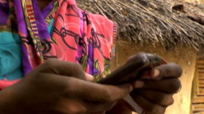 An Indian women transferring money on a mobile phone